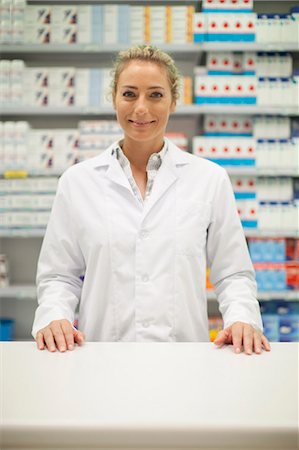 Pharmacist smiling behind counter Foto de stock - Sin royalties Premium, Código: 6122-07705758