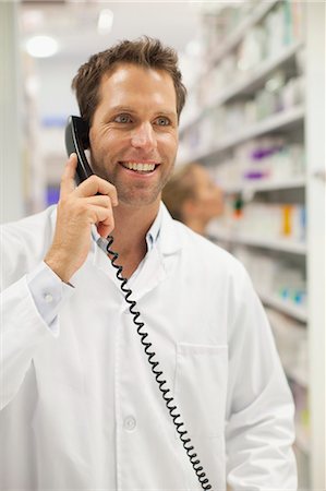 supplies (stock of essential items needed to sustain life) - Pharmacist talking on phone Foto de stock - Sin royalties Premium, Código: 6122-07705770