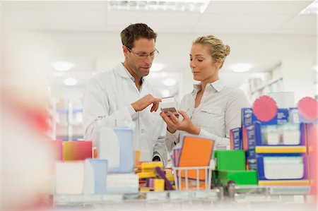 people looking up and pointing - Pharmacist helping patient in store Stock Photo - Premium Royalty-Free, Code: 6122-07705771