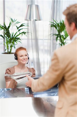 recepção - Receptionist giving newspaper to man Foto de stock - Royalty Free Premium, Número: 6122-07705731