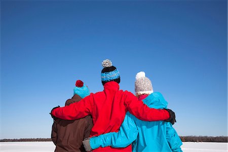 Friends hugging in snowy field Stock Photo - Premium Royalty-Free, Code: 6122-07705882