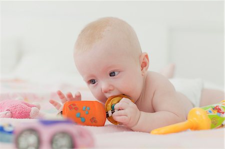 simsearch:649-07064496,k - Baby chewing on rattle on blanket Stock Photo - Premium Royalty-Free, Code: 6122-07705805