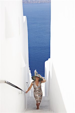 santorini island greece and people - Woman walking up narrow staircase Stock Photo - Premium Royalty-Free, Code: 6122-07705960