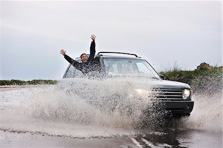 Man leaning out of splashing car Stock Photo - Premium Royalty-Free, Code: 6122-07705994
