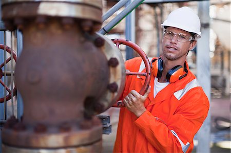 Worker adjusting gauge at oil refinery Photographie de stock - Premium Libres de Droits, Code: 6122-07706253