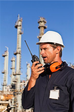 refinería de petróleo - Worker using walkie talkie on site Foto de stock - Sin royalties Premium, Código: 6122-07706258