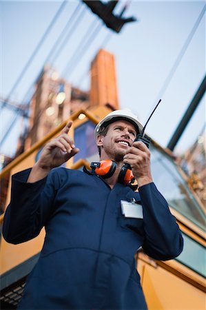 Worker using walkie talkie on site Stock Photo - Premium Royalty-Free, Code: 6122-07706263