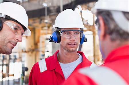 Workers talking at oil refinery Stock Photo - Premium Royalty-Free, Code: 6122-07706274