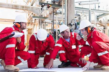 Workers with blueprints at oil refinery Foto de stock - Sin royalties Premium, Código: 6122-07706275