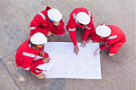 Workers with blueprints at oil refinery Stock Photo - Premium Royalty-Free, Code: 6122-07706276