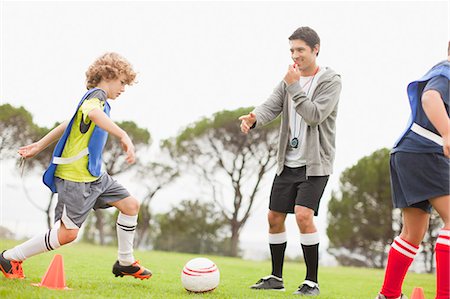 soccer field kid - Coach training childrens soccer team Stock Photo - Premium Royalty-Free, Code: 6122-07706203