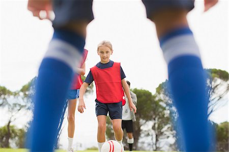 simsearch:649-06040320,k - Girl playing soccer on pitch Stock Photo - Premium Royalty-Free, Code: 6122-07706207