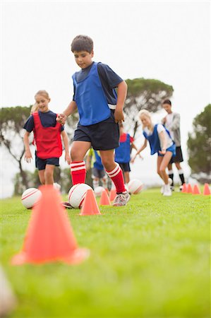 Childrens soccer team training on pitch Foto de stock - Sin royalties Premium, Código: 6122-07706205