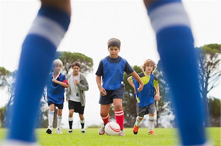 simsearch:614-02984344,k - Boys playing soccer on pitch Photographie de stock - Premium Libres de Droits, Code: 6122-07706206