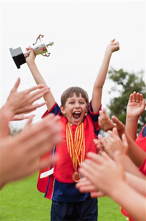 simsearch:649-06040320,k - Children cheering teammate with trophy Stock Photo - Premium Royalty-Free, Code: 6122-07706215