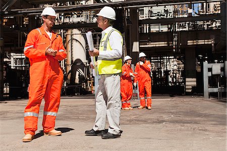 Workers talking at oil refinery Stock Photo - Premium Royalty-Free, Code: 6122-07706230