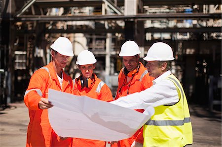 Workers with blueprints at oil refinery Stock Photo - Premium Royalty-Free, Code: 6122-07706232