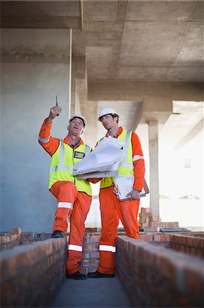 Workers reading blueprints on site Stock Photo - Premium Royalty-Free, Code: 6122-07706381