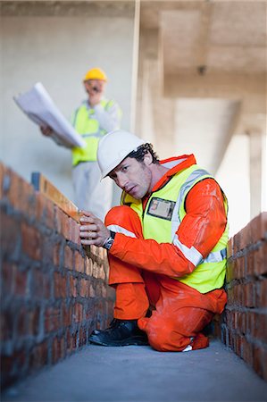 Worker laying brick at construction site Foto de stock - Sin royalties Premium, Código: 6122-07706382