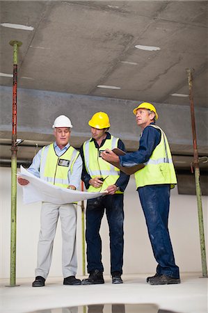 Workers reading blueprints on site Stock Photo - Premium Royalty-Free, Code: 6122-07706387