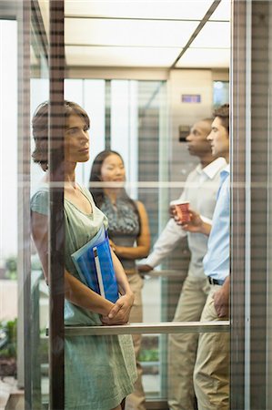 Business people riding glass elevator Stock Photo - Premium Royalty-Free, Code: 6122-07706337