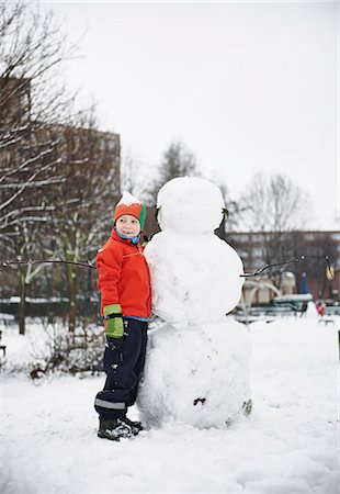 snowman and child - Boy building snowman in park Stock Photo - Premium Royalty-Free, Code: 6122-07706440