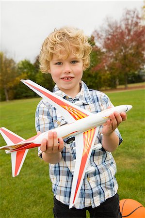 Boy playing with toy airplane outdoors Stock Photo - Premium Royalty-Free, Code: 6122-07706552