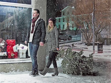 snow fun - Couple carrying Christmas tree in snow Stock Photo - Premium Royalty-Free, Code: 6122-07706505