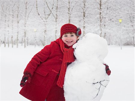 female snowman pictures - Smiling girl hugging snowman outdoors Stock Photo - Premium Royalty-Free, Code: 6122-07706511