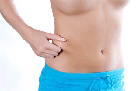 slim belly - Woman pinching belly skin Stock Photo - Premium Royalty-Free, Code: 6122-07706669