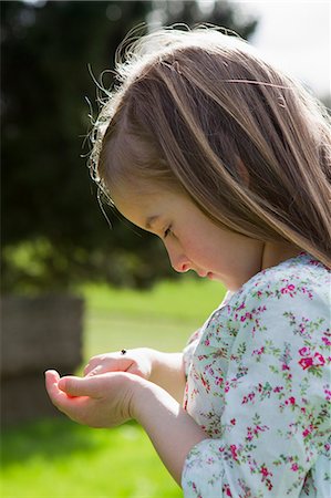simsearch:6122-07703503,k - Girl examining insect on hand outdoors Stock Photo - Premium Royalty-Free, Code: 6122-07706699