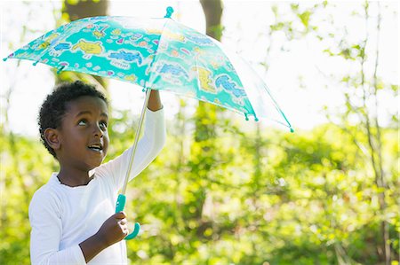 Boy carrying umbrella in forest Stock Photo - Premium Royalty-Free, Code: 6122-07706783