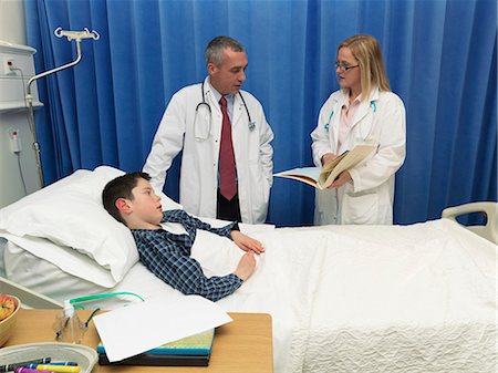 simsearch:6113-07146717,k - Doctors examining patient in hospital Photographie de stock - Premium Libres de Droits, Code: 6122-07706720