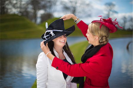 Women adjusting decorative hats Stock Photo - Premium Royalty-Free, Code: 6122-07706891