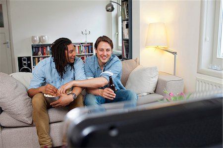 simsearch:649-06112975,k - Men watching television in living room Stock Photo - Premium Royalty-Free, Code: 6122-07706829