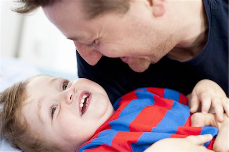 dad and baby laughing - Smiling father playing with son Stock Photo - Premium Royalty-Free, Code: 6122-07706966