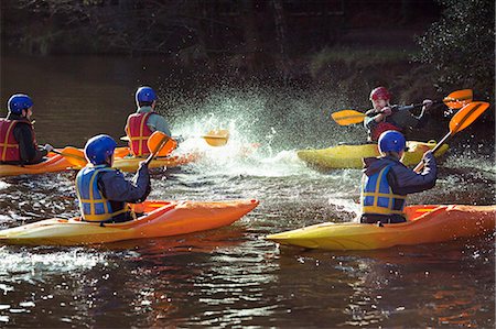 Kayakers rowing together on still lake Stock Photo - Premium Royalty-Free, Code: 6122-07707049