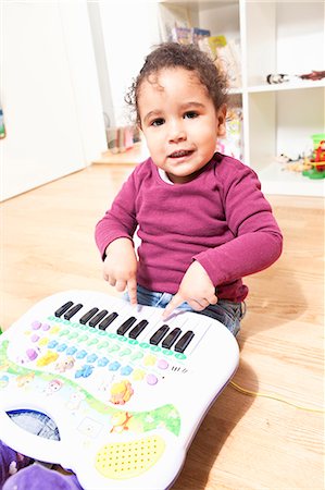 Girl playing with toy piano Stock Photo - Premium Royalty-Free, Code: 6122-07707183