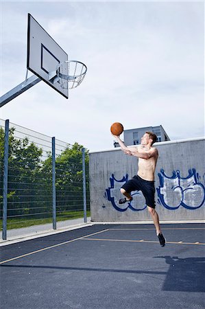 simsearch:6122-08229539,k - Man playing basketball on urban court Photographie de stock - Premium Libres de Droits, Code: 6122-07707181