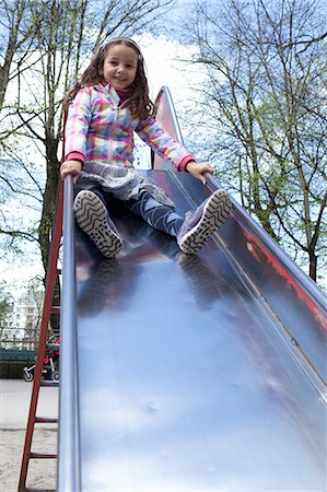 simsearch:695-05764298,k - Girl playing on slide in playground Photographie de stock - Premium Libres de Droits, Code: 6122-07707186