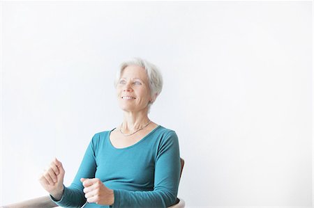 people sitting cutout white background - Smiling older woman sitting in chair Stock Photo - Premium Royalty-Free, Code: 6122-07707119