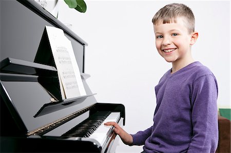 simsearch:6122-08229162,k - Smiling boy practicing at piano Foto de stock - Sin royalties Premium, Código: 6122-07707204