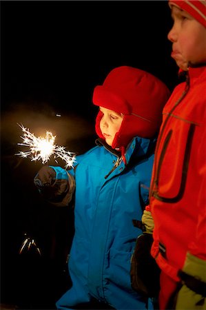 simsearch:6122-07706907,k - Boy playing with sparkler outdoors Foto de stock - Sin royalties Premium, Código: 6122-07707395