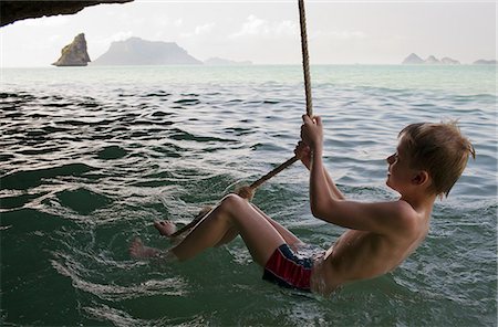 simsearch:400-05097844,k - Boy playing on rope over water Stock Photo - Premium Royalty-Free, Code: 6122-07707455