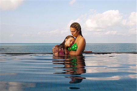 Mother and daughter in infinity pool Photographie de stock - Premium Libres de Droits, Code: 6122-07707458