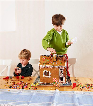 Boys decorating gingerbread house Fotografie stock - Premium Royalty-Free, Codice: 6122-07707400