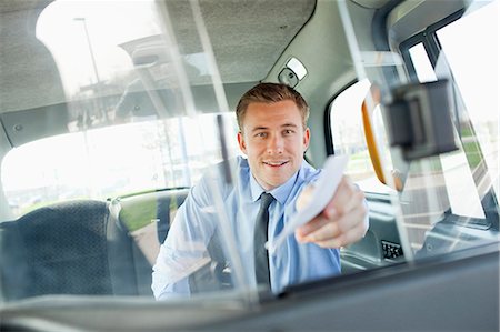 Businessman paying taxi driver Stock Photo - Premium Royalty-Free, Code: 6122-07707426