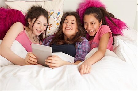 simsearch:6122-07702347,k - teenage girls reading electronic tablet in bed Stock Photo - Premium Royalty-Free, Code: 6122-08211943