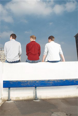 simsearch:695-03373539,k - Men sitting on rooftop wall Stock Photo - Premium Royalty-Free, Code: 6122-08212064