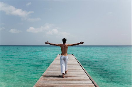 dock in maldives - Man walking on deck overlooking sea Stock Photo - Premium Royalty-Free, Code: 6122-08212097